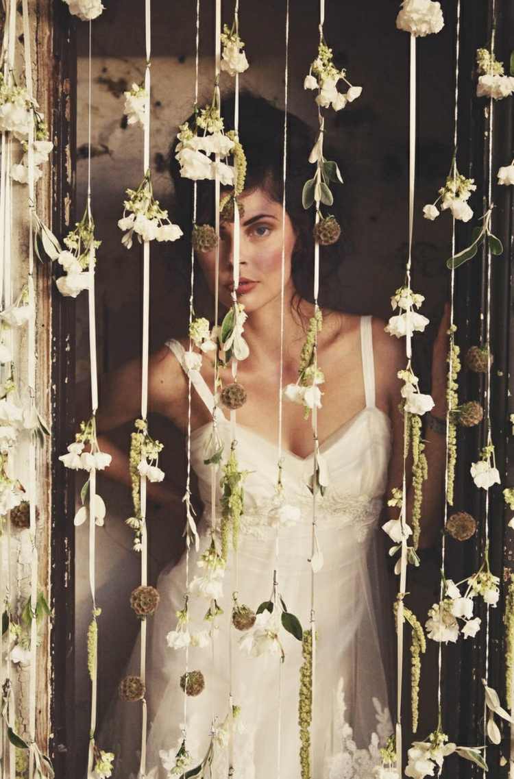 Braut mit Blüten Vorhang für das Fotoshooting zur Hochzeit