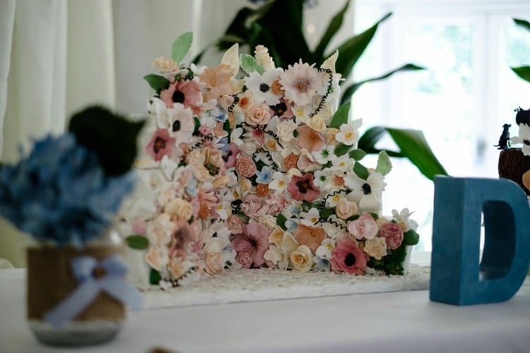 Eine Hochzeitstorte mit Blumen und gespaltenem Design wirkt sehr romantisch