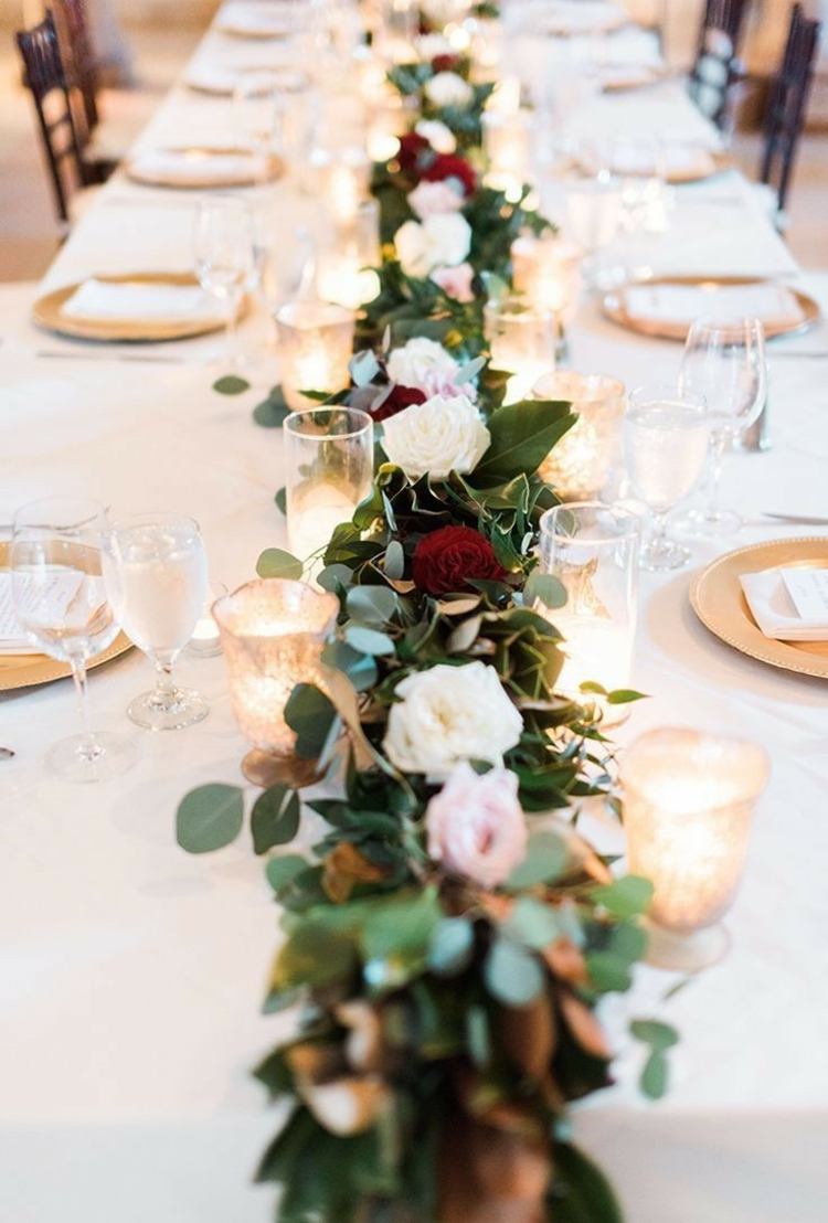Tischdeko mit Rosen in verschiedenen Farben und Windlichter und Geschirr in Gold