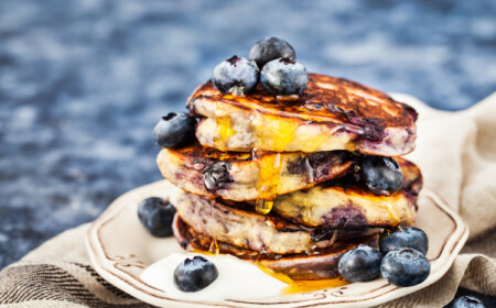 amerikanische Pancakes mit Blaubeeren, Joghurt und Ahornsirup