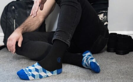 blaue geometrische figuren auf socken wirkend als füßlinge und schwarze enge jeans