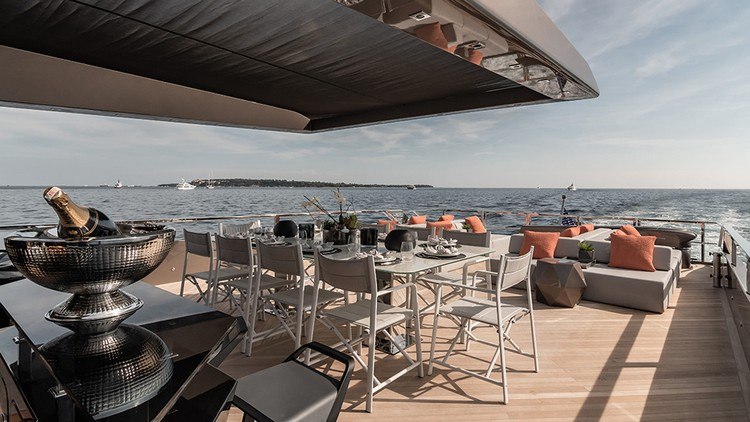 luxus yacht deck mit champagnier und edlen details wie esstisch und sitzmöbel