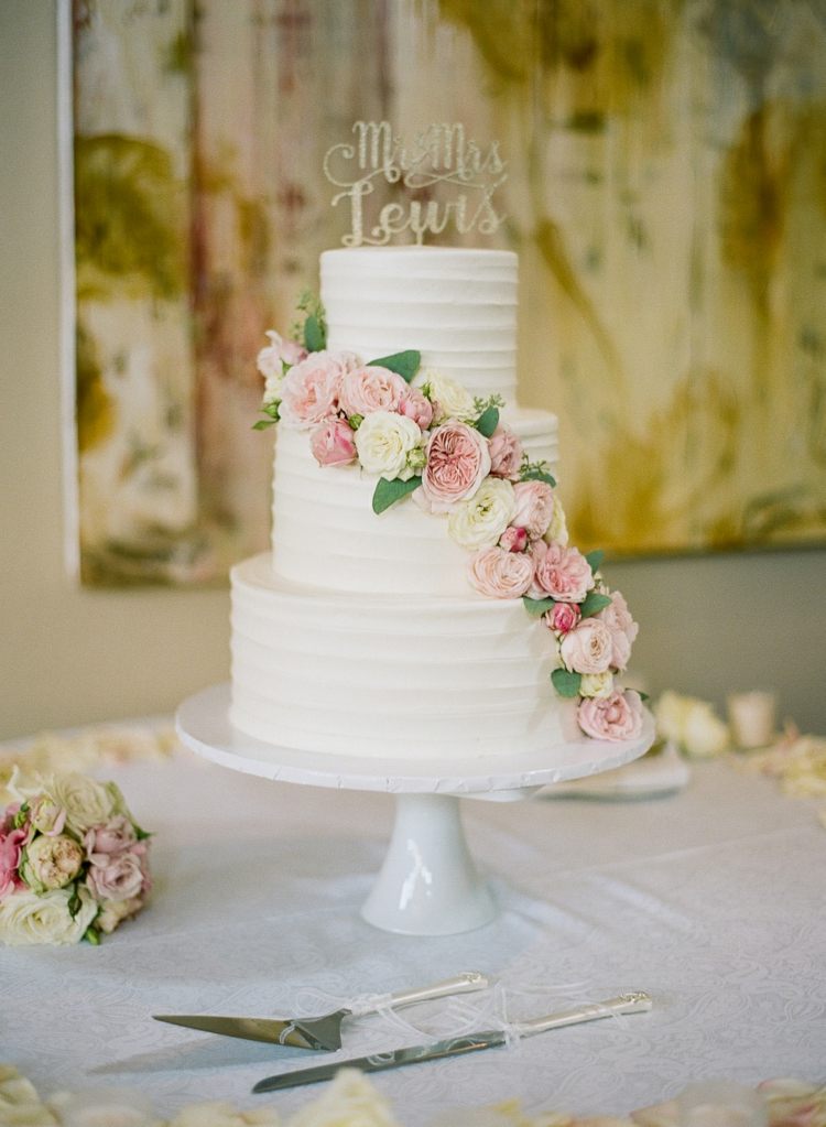 schlichte Torte mit Blumengirlande passend zum weißen Brautkleid