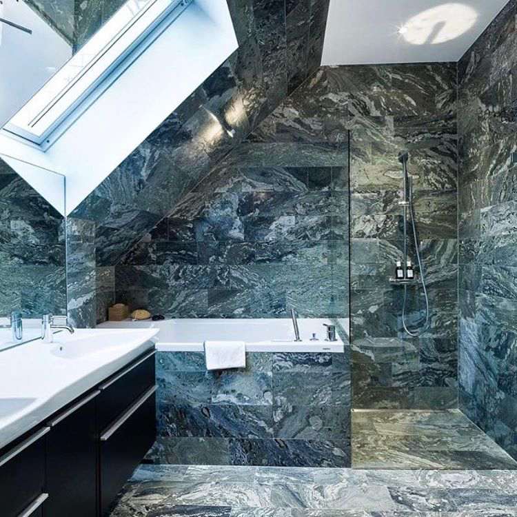 Badezimmer mit Dachschräge Badewanne und Dusche Boden- und Wandfliesen in Marmoroptik
