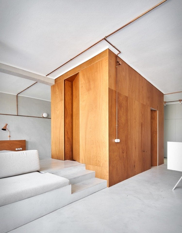 Mikrozement und Holzschrank im Schlafzimmer in Mikrowohnung