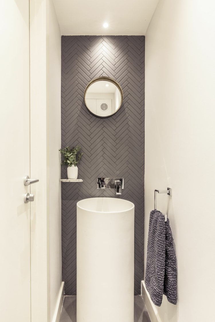 Mini Waschraum mit modernem Säulen-Waschbecken und rundem Spiegel