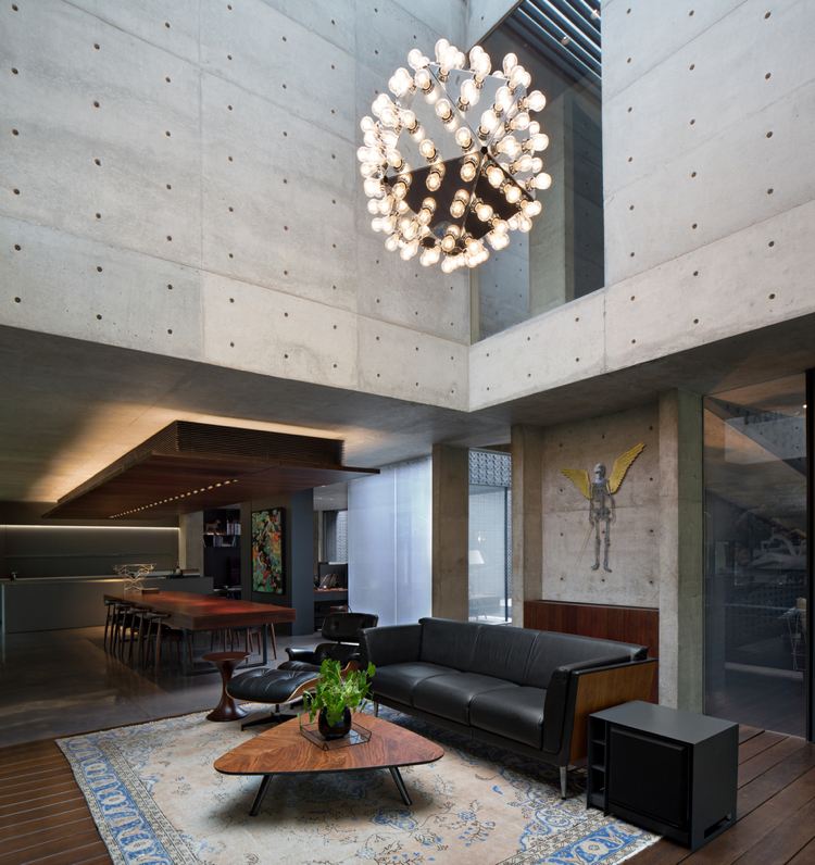 Sichbeton Innenwände Holz Kaffeetisch Wohnzimmer hohe Decke moderner Kronleuchter