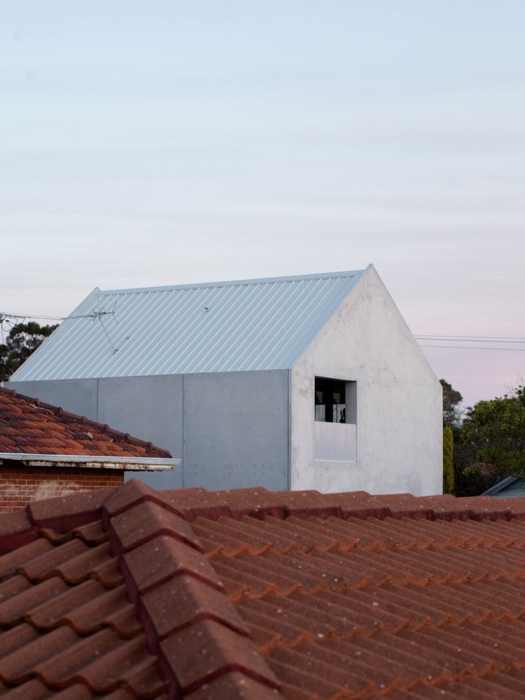 behausung des viertels mit roten dächern und kontrastierendem haus mit betonwänden in grau