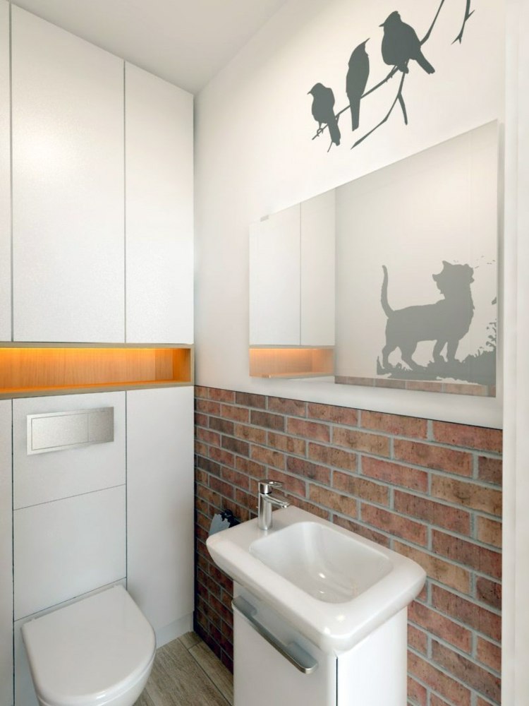 ein helles WC für die Gäste mit Backsteinwand und Akzent in Orange