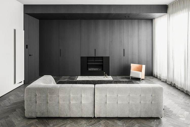 großes wohnzimmer mit kamin und minimalistischen formen sowie eine graue farbpalette