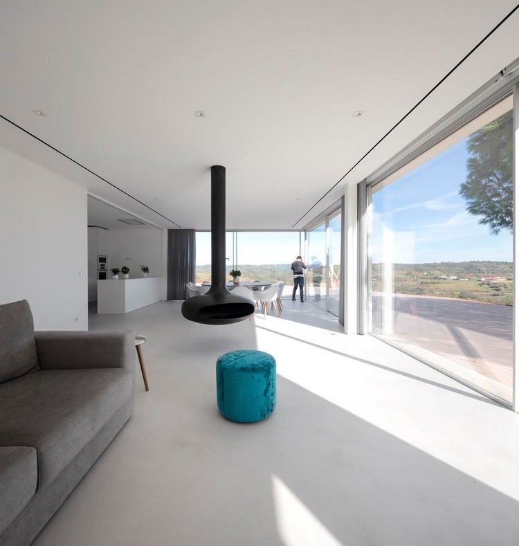 minimalistisch eingerichteter innenraum mit kamin sofa und glasschiebetüren
