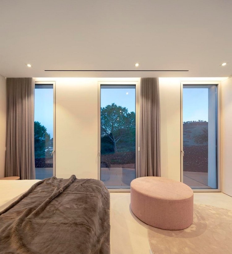 minimalistisches schlafzimmer mit drei deckenhohen glastüren und deckenbeleuchtung