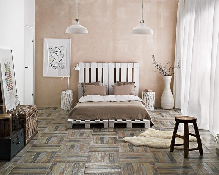 rustikal eingerichtetes minimalistisches schlafzimmer mit palettenbett in weiß hocker und bilder