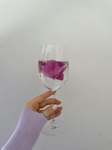 schwimmende blütenblätter im weinglas