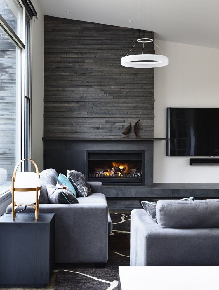 steinriemchen in grau mit kamin im wohnraum gestaltet mit grauen polstermöbeln