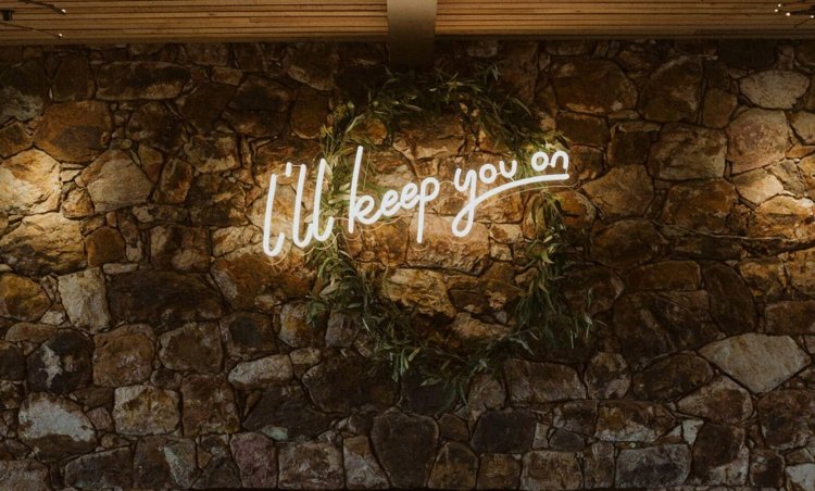 Neon Schriftzug für die Wand aus Stein bei einer rustikalen oder mediterranen Hochzeit
