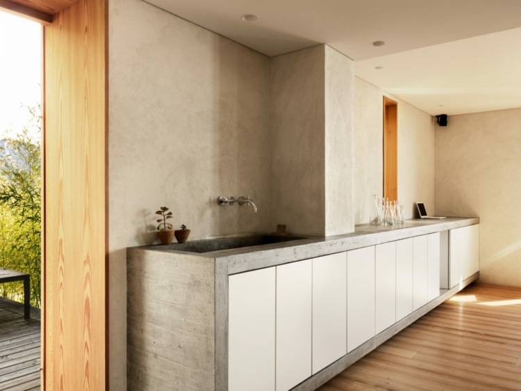 Rahmen aus Beton für weiße minimalistische Küchenschränke