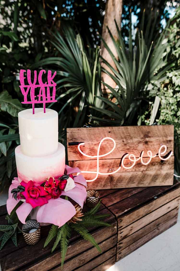 Rustikales Holzbrett mit Neon Schriftzug Love und lustiger Tortendeko