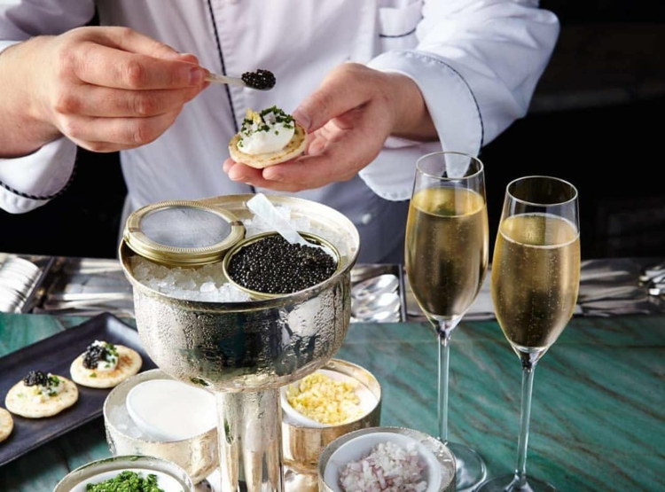 Schwarzer Kaviar servieren Eisbett Champagner russische Pfannkuchen Blinis Rezept Sauerrahm