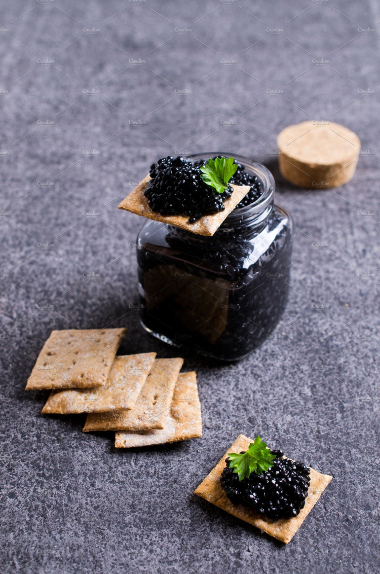 Schwarzer Kaviar servieren und essen Beilagen Cracker Gourmetessen