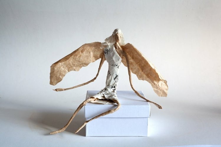 Sitzender Engel mit Flügel aus Papier