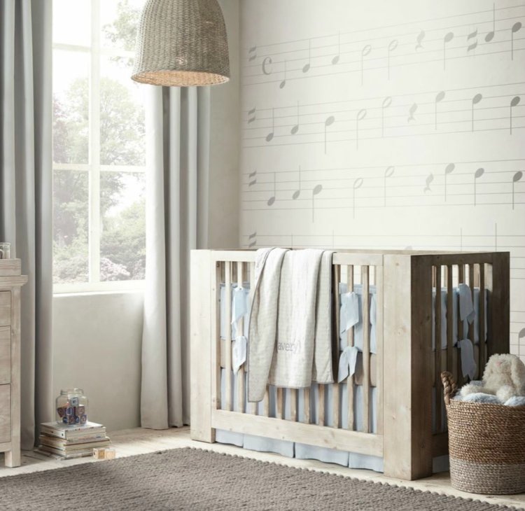 Tapete mit Noten und rustikales Babybett für eine moderne Gestaltung