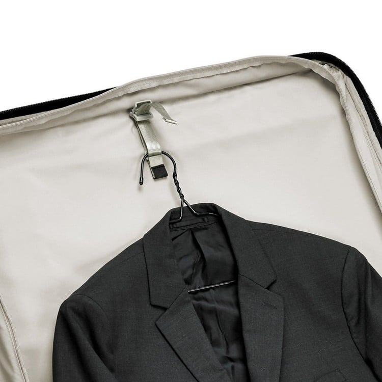 anzug mit kleiderbügel am koffer befestigen um falten während fahrt oder flug zu vermeiden