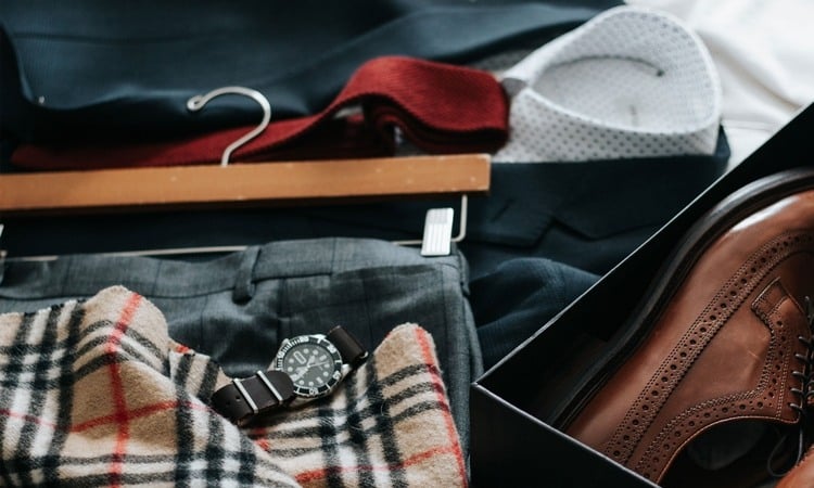anzughose auf kleiderbügel und schuhe im karton faltenfrei packen mit anderen accessoires im koffer positionieren