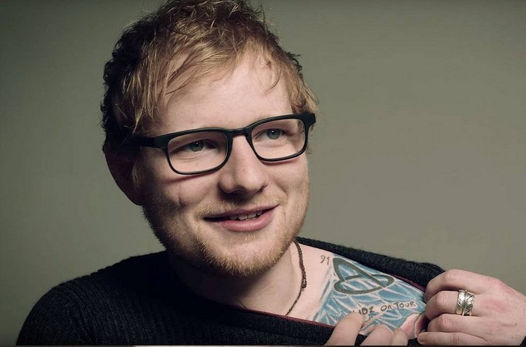 foto von ed sheeran zeigend auf sein tattoo auf dem schulter