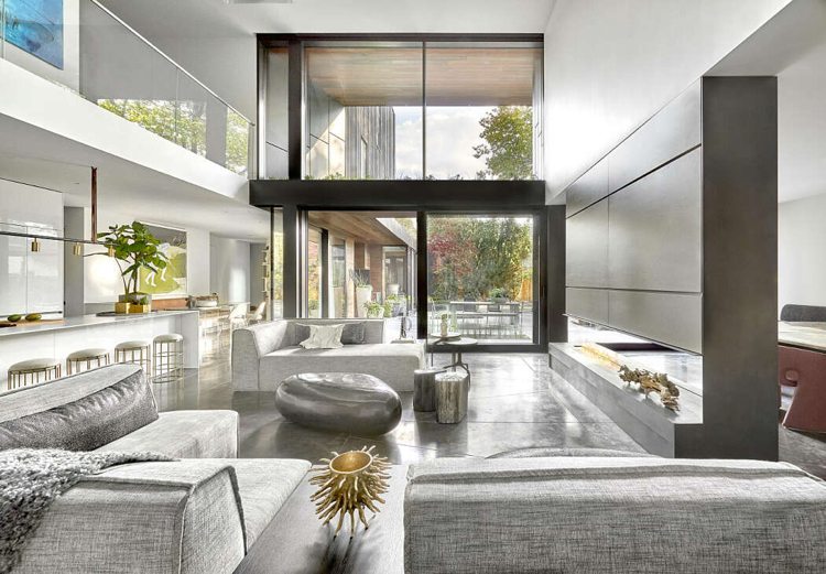 gedeckte Farben Wohnbereich bodengleiche Fenster weiße Wände graue Polstermöbel 3-seitige Kamin