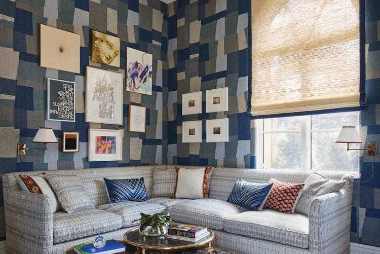 kubistisch geometrische wandmuster in blau als collage im wohnzimmer mit ecksofa in grau