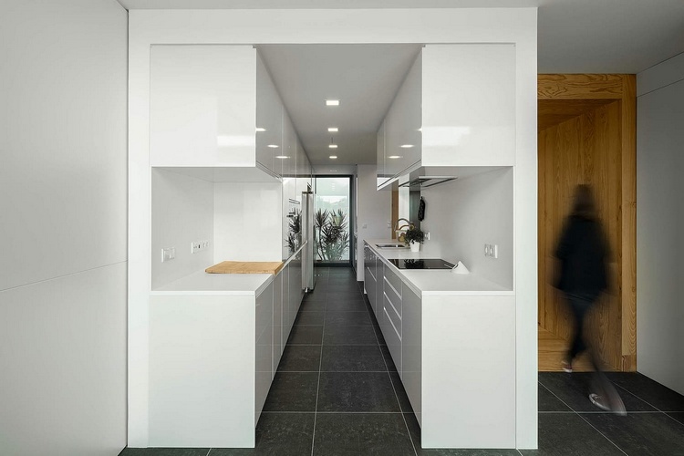 moderne minimalistische zweireihige küche in weiß mit fliesenboden in grau
