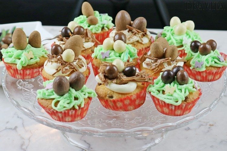 osternest cupcakes mit glasur und schokoeiern dekoriert auf einem tablett aus glas servieren