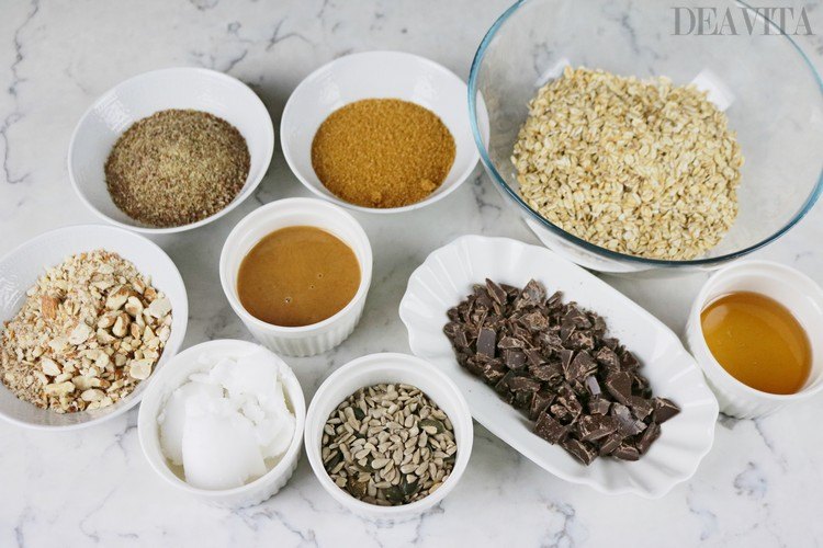 produkte und zutaten für granola müsli brauner zucker leinsamen schokoladenstückchen honig mandeln kokosnussöl