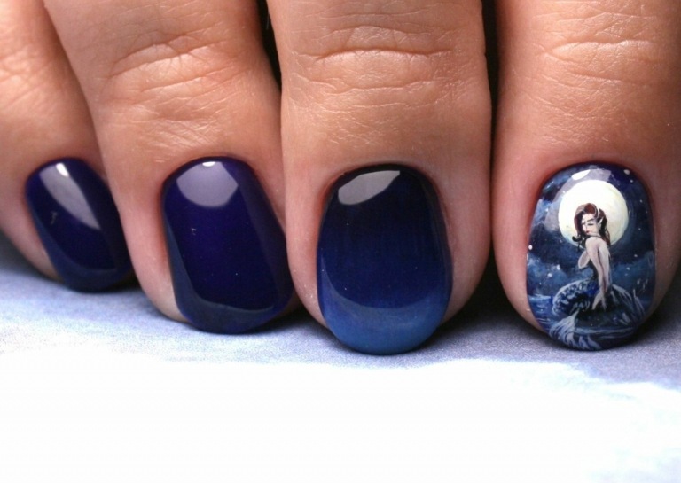 Diese dunkelblauen Fingernägel imitieren die Nacht und besitzen eine Meerjungfrau als Motiv