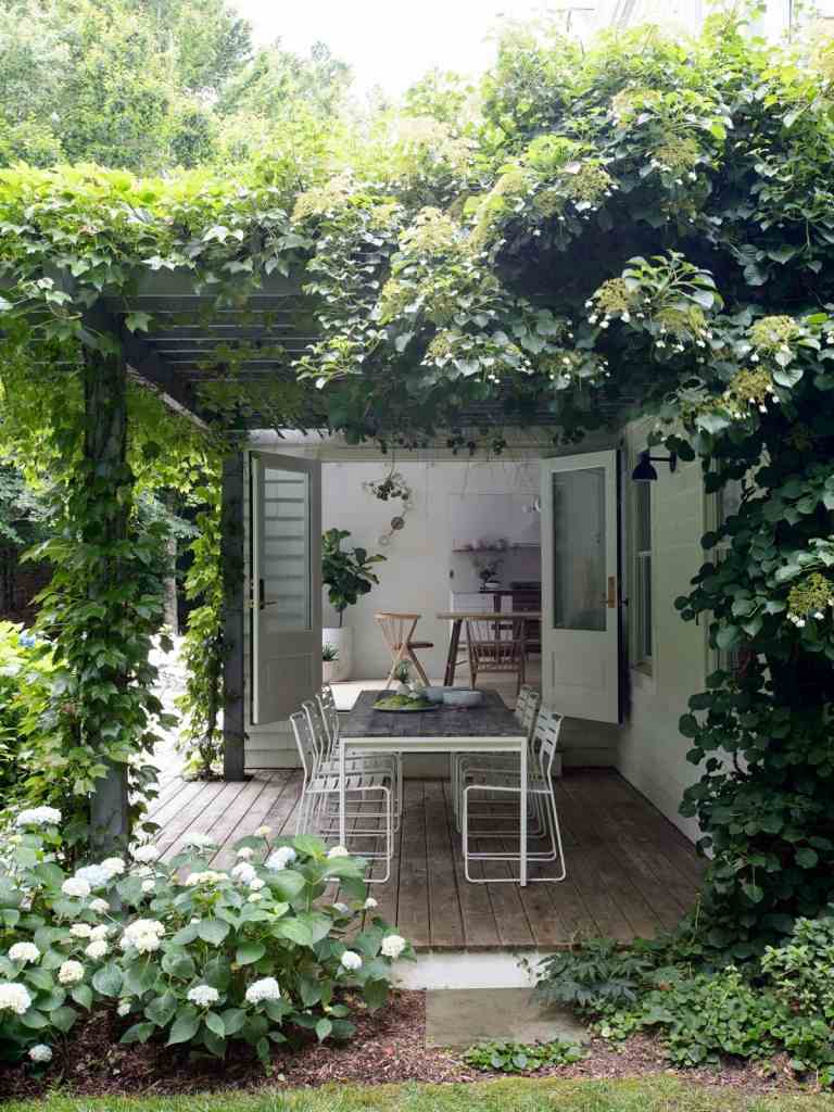 Ein romantischer Cottage-Garten mit skandinavischen Möbeln auf der Terrasse