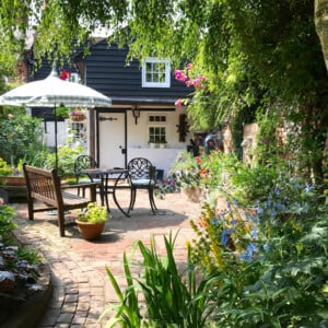 Gartenideen Terrasse bienenfreundlich Blumen Mosaik Stein Sonnenschirm Gartentrends