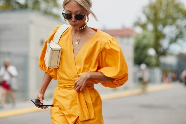 Kleid mit Puffärmeln kombinieren gelb Lederhandtasche blonde Haare Outfit Sommer Frauen