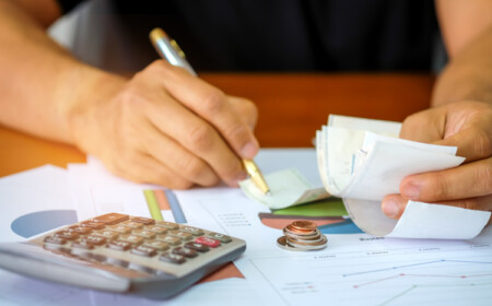 Nebenkostenabrechnung als Vermieter erstellen sich durch mehrere Papierstapel wühlen