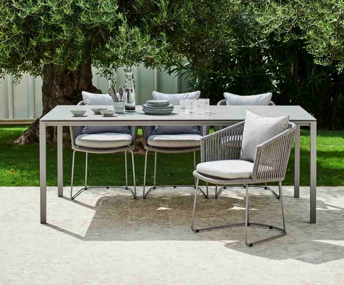 Schicker Esstisch mit passenden Stühlen im gewebtem Design für Familienessen im Garten