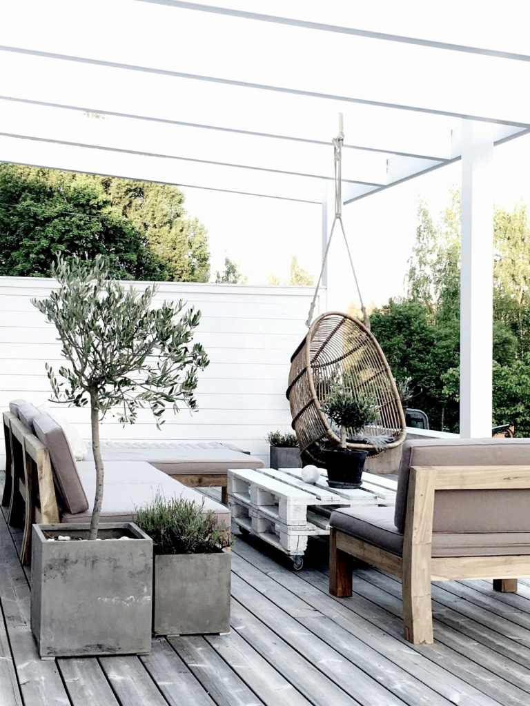 Terrasse skandinavisch gestalten mit Holzdeck Kübeln aus Beton und Paletten für den Tisch