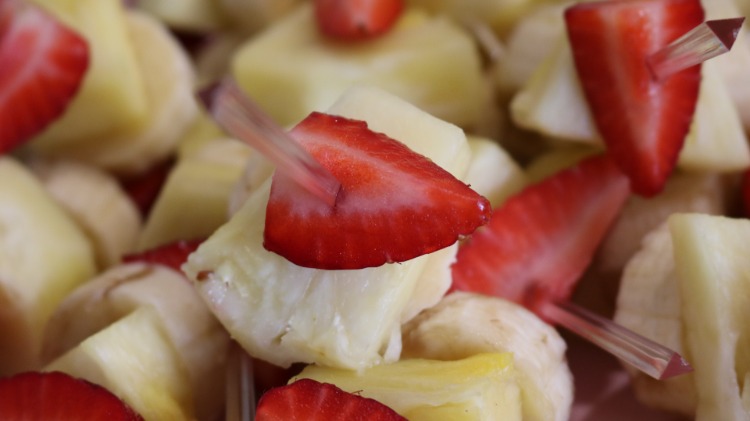 fingerfood obst aus ananas erdbeeren und bananen aufgespießt mit partypicker