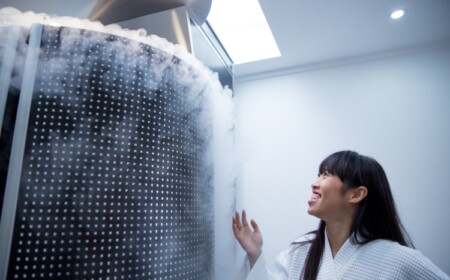 frau bewundert die physikalische therapie von kryokammer mit dampfendem eis