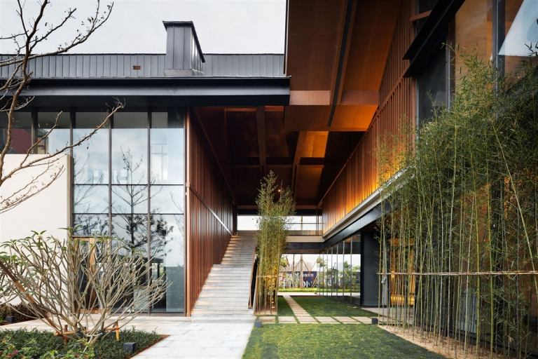 verspiegelte fassade Glasfronten Holzakzente Bambus Vorgarten