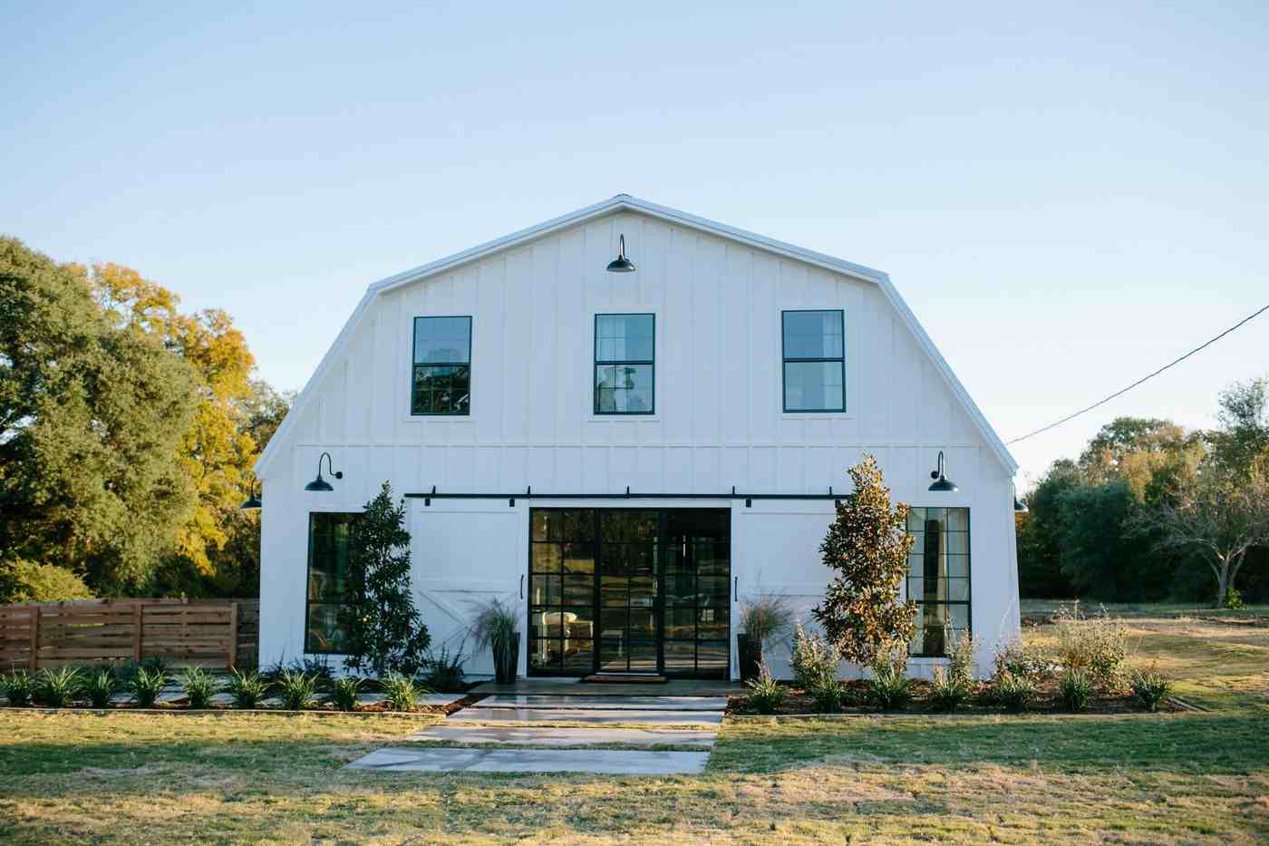 Barndominiums modern umgebaute Scheune weiße Fassade Vorgartengestaltung mit Gräsern