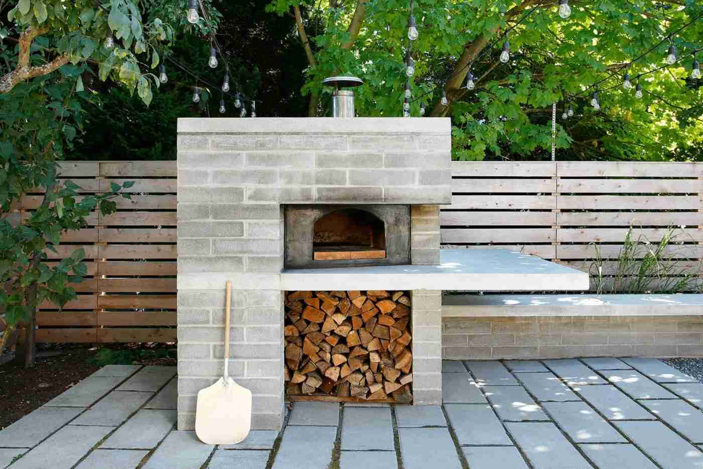 Beton im Garten für den Grill mit Fach für das Feuerholz und Platten als Bodenbelag