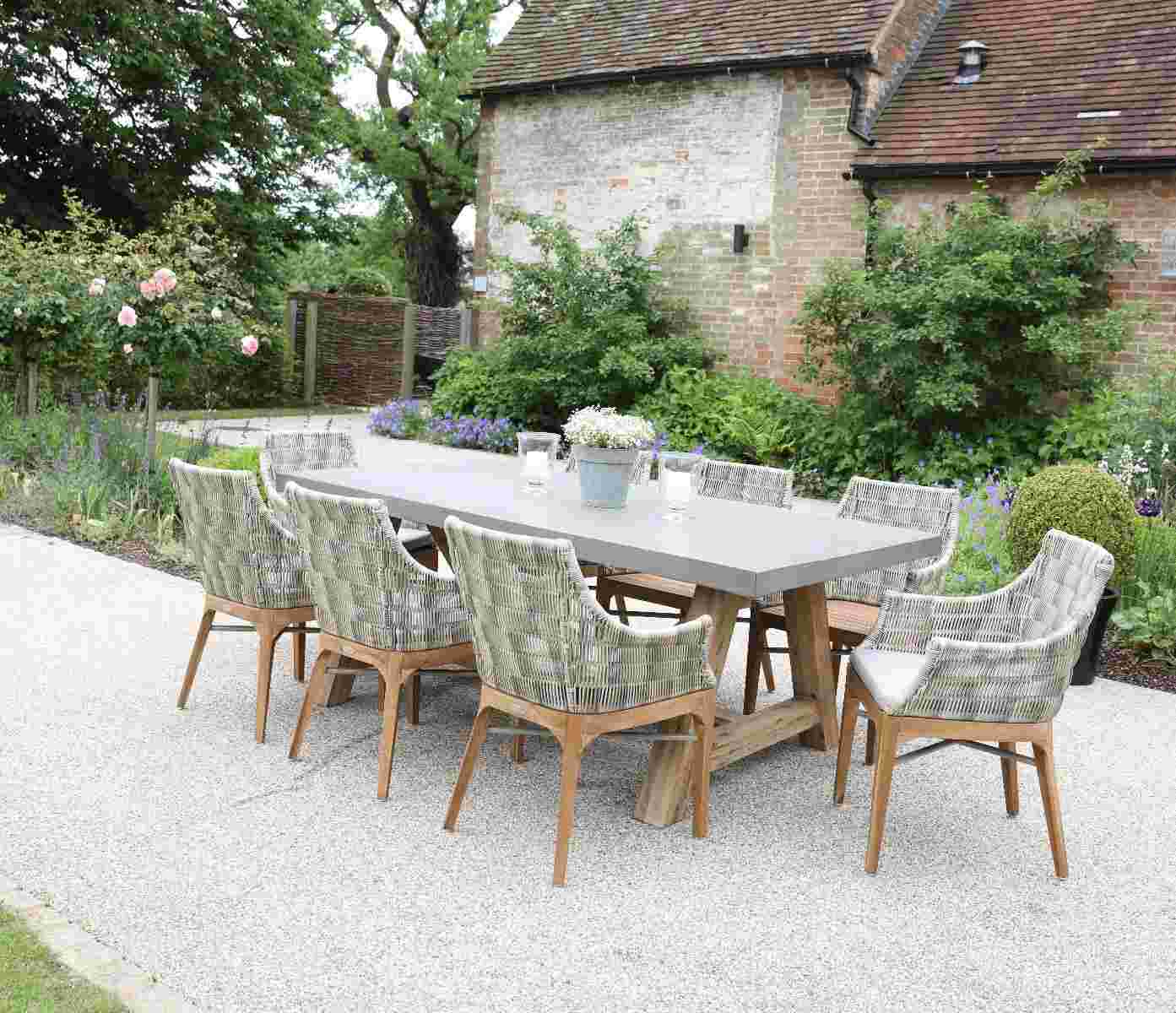 Esstisch mit Tischplatte aus Beton und Beinen aus Holz in einem Cottage Garten