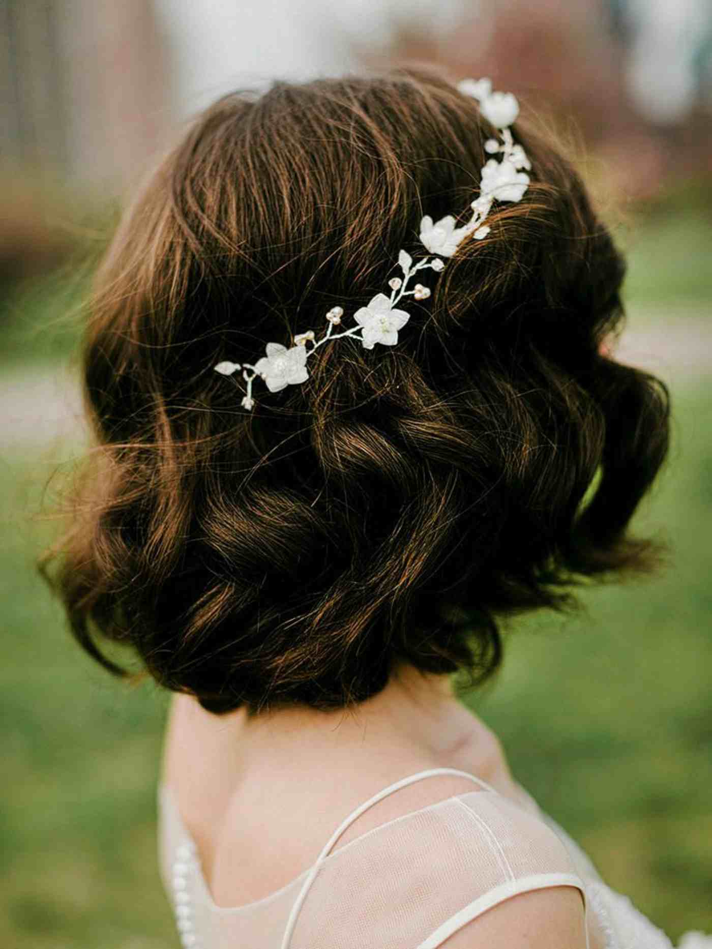 Feminine Brautfrisur mit kurzen Haaren und Haarschmuck mit Blüten.
