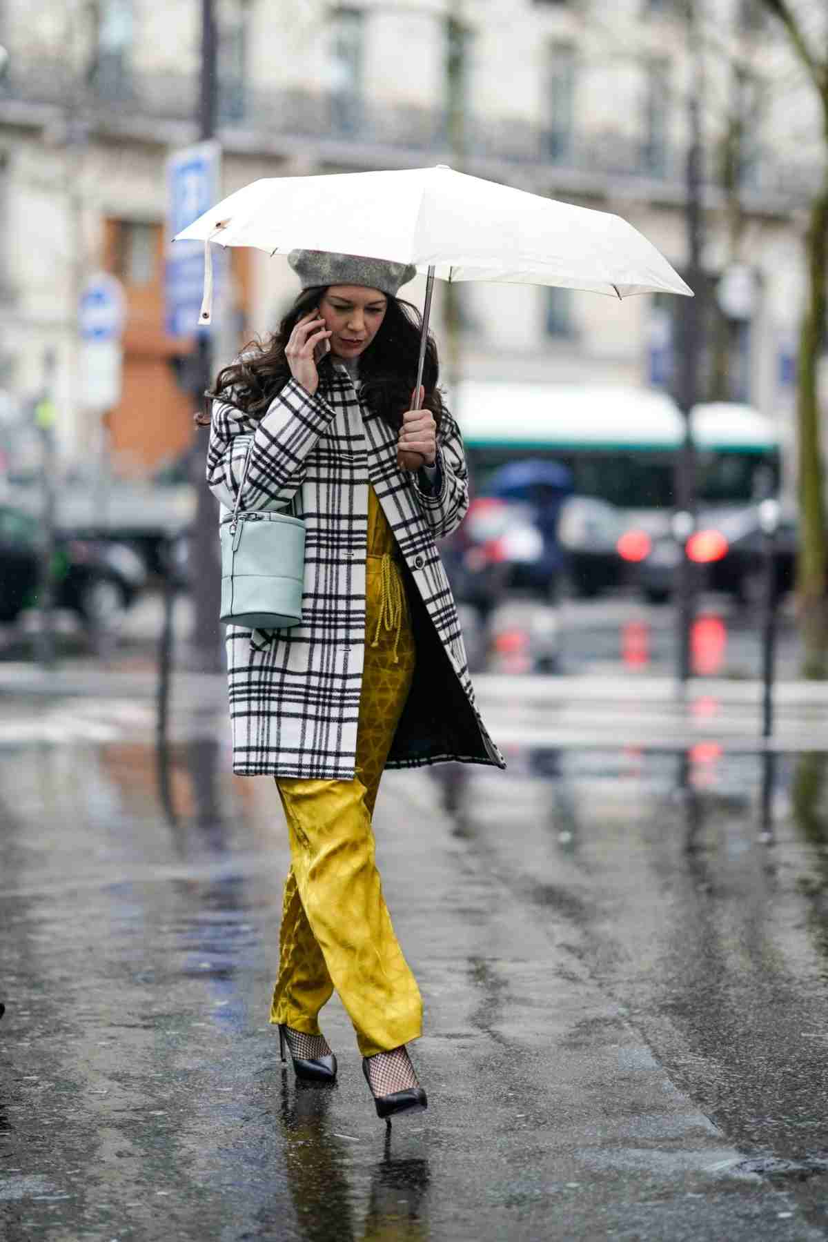 Gelbe Hose, Pumps und karierter Trenchcoat als Regenbekleidung für Damen