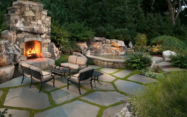 Idee für einen Gartenteich mit Sitzbereich und Kamin aus Stein